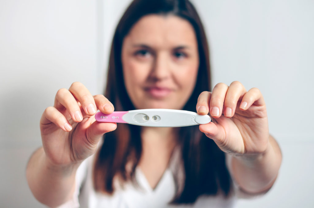 Femme Enceinte montrant un test de grossesse